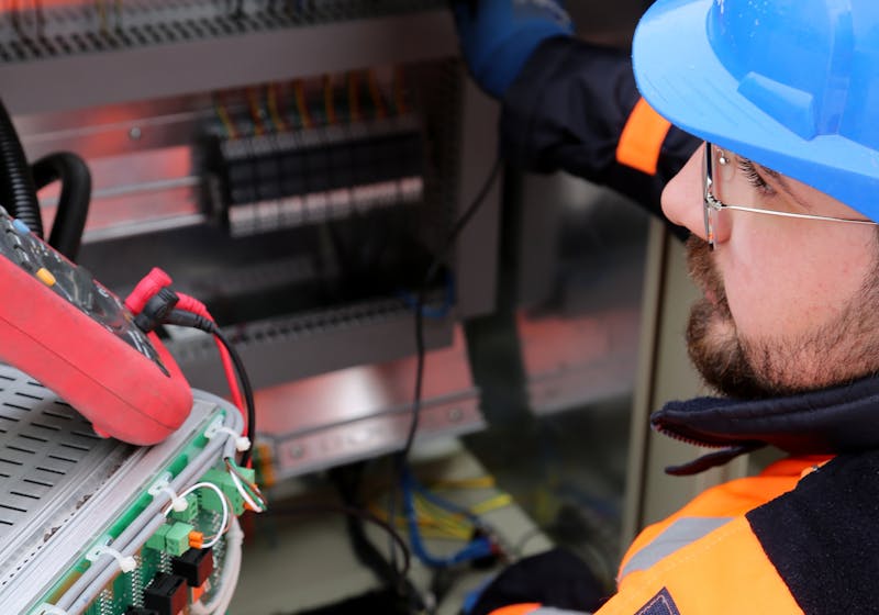 Licensed electrician inspecting circuit breaker panel for diagnostics